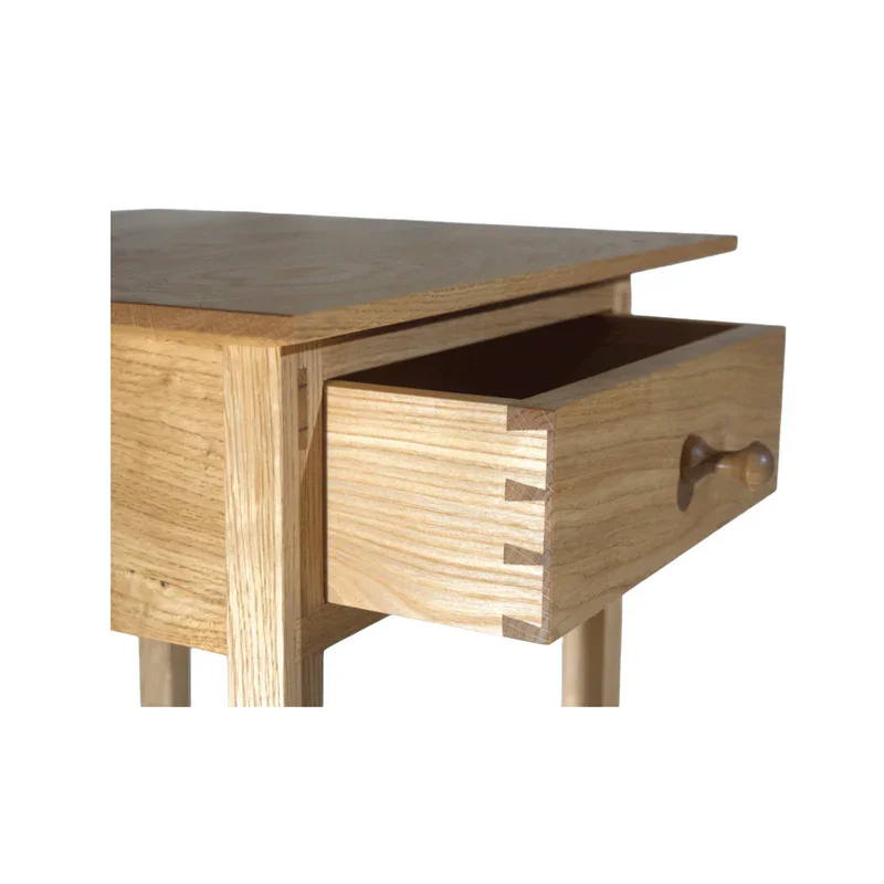 Holztisch mit einer offenen Schublade und Holzknauf gegen weißen Hintergrund von Kalle Warncke