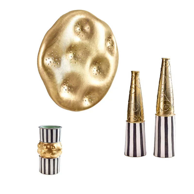 Dekorative Gegenständen Elke Eder-Eich in Schwarz-Weiß Streifen mit Goldakzenten, inklusive einer großen goldenen Kugel und zwei kleinen zerbecherförmigen Objekten mit Goldverzierungen.