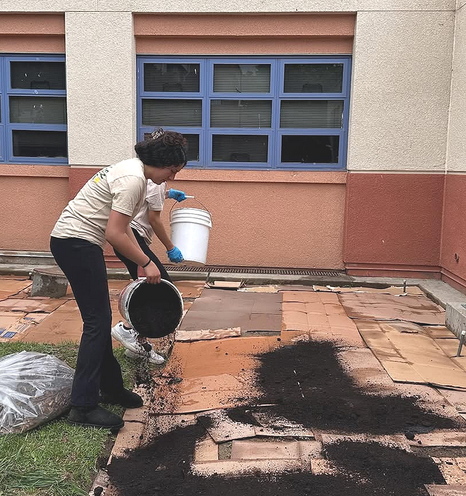Student spreading compost over cardboard at Oxnard High School