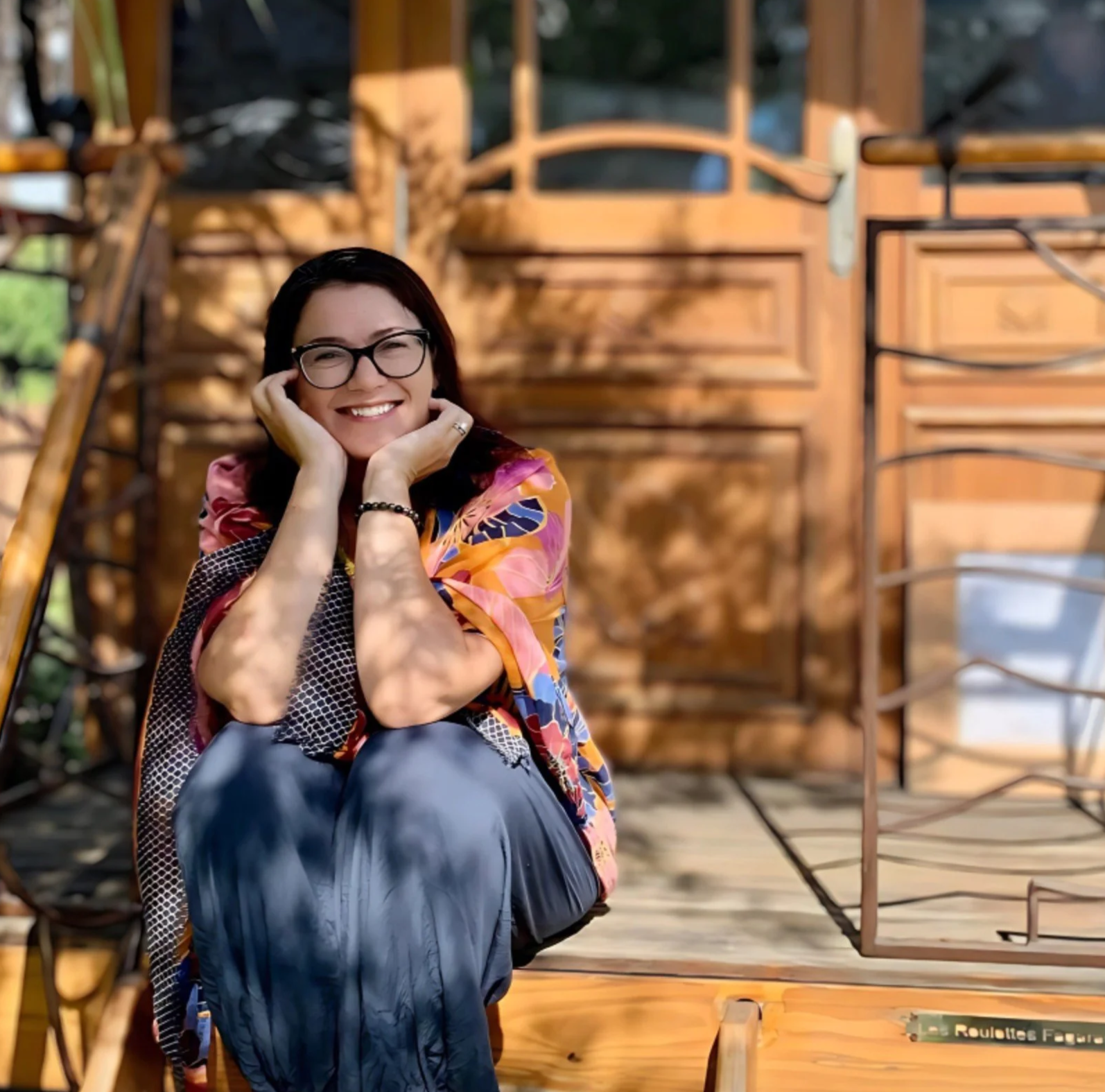 Gitane Ouellet sitting on a wooden porch.