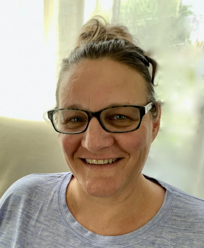 Kim LeClair sitting indoors near a window.