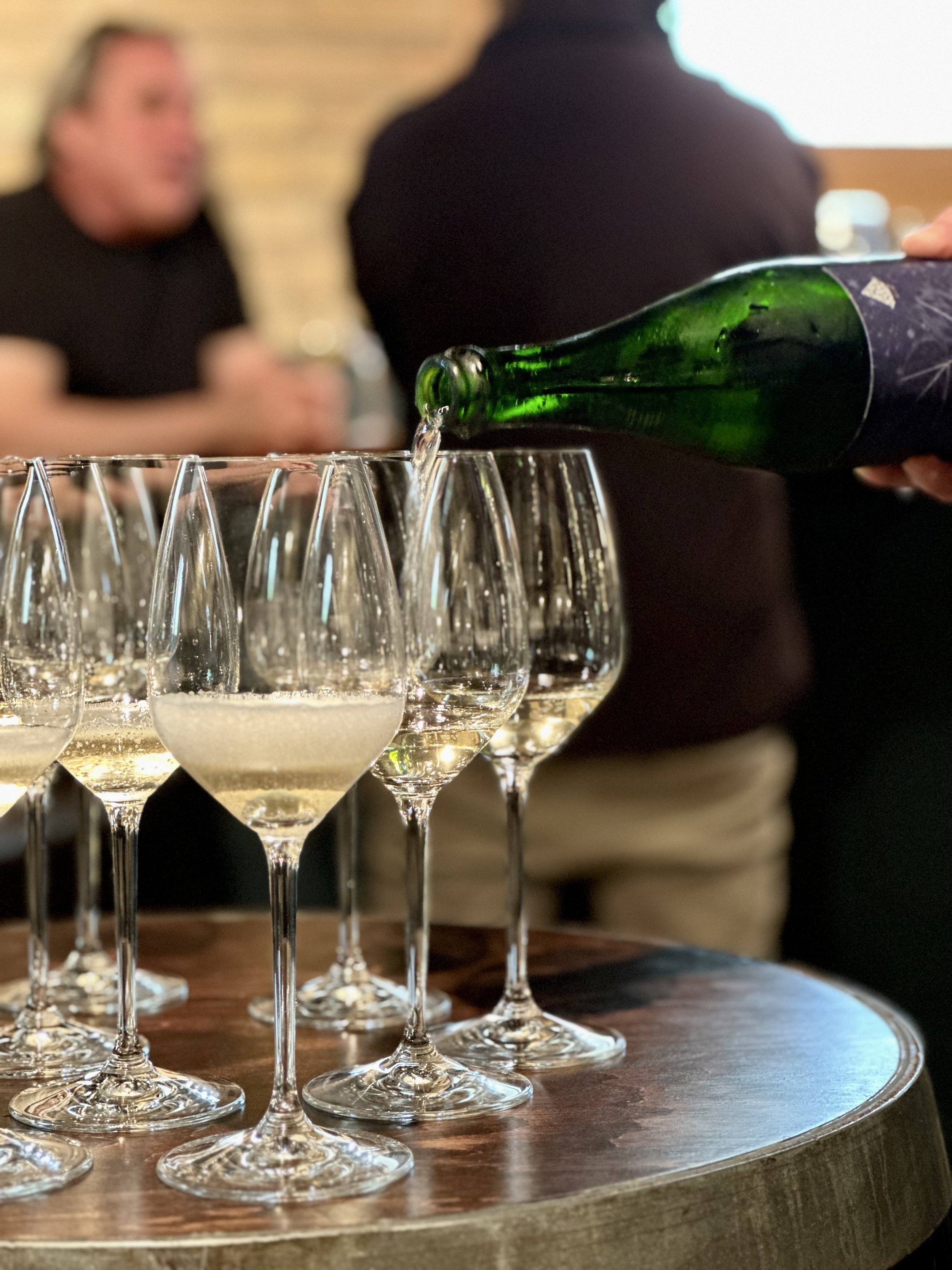 sparkling wine being poured into wine glasses