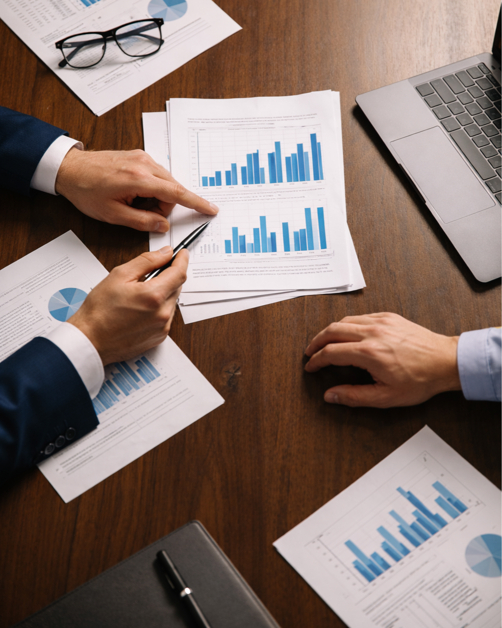 Two professionals reviewing employee benefits cost analysis charts during a strategy meeting