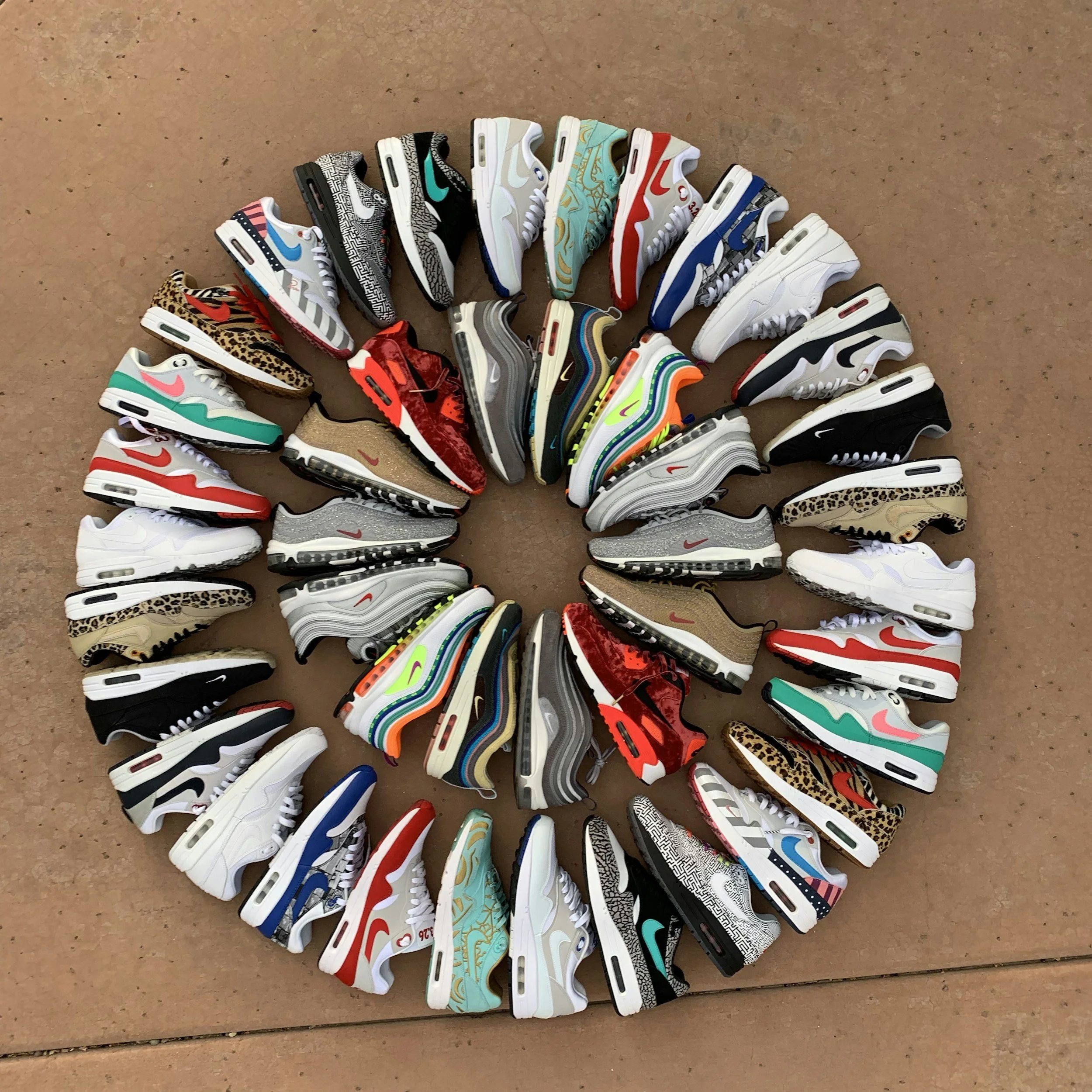 A sneaker display room with shelves filled with sneakers, a Jordan logo on the wall, and a Supreme chair, with a rug on the floor that says 'KEEP OFF!'.
