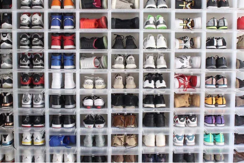 A neatly organized wall of multiple compartments filled with various pairs of sneakers.