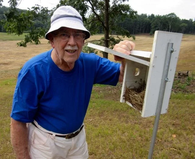 Ray Van Vorse standing next to birdhouse