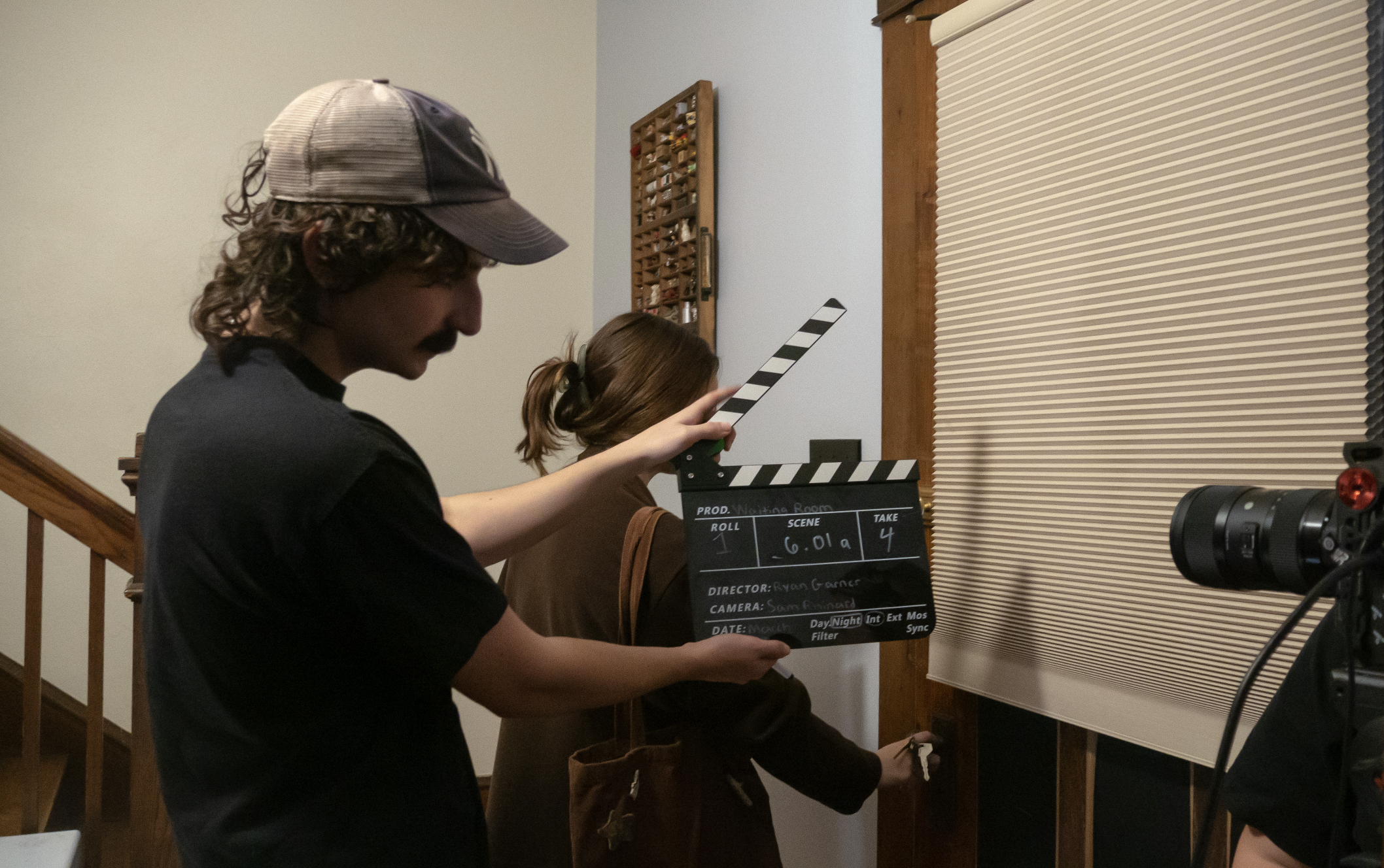 The star actor of the film in action while the slate is in frame behind the scenes during the filming of Waiting Room, a film by Good Fortune Pictures