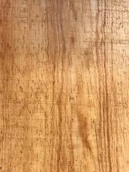 Close-up of a natural wood surface showing visible grain patterns and texture.