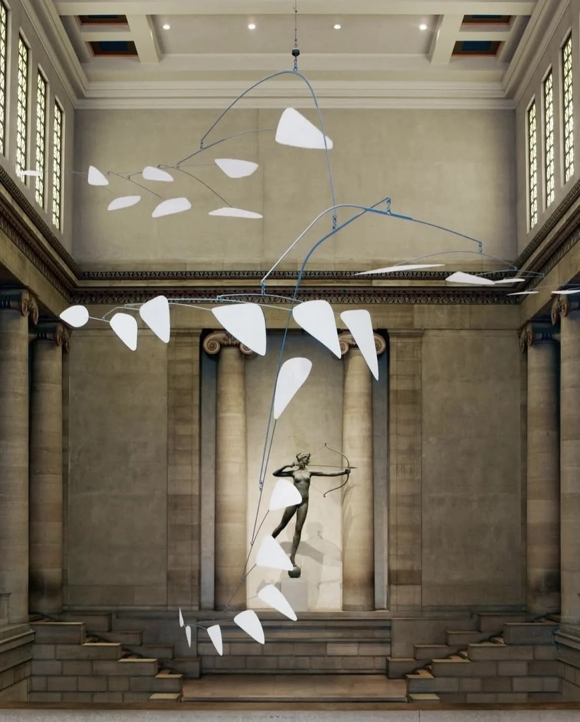 An art installation in a classical-style hall with tall windows, featuring a bronze statue of a woman aiming a bow. Above, suspended abstract white shapes with blue wires create a dynamic mobile-like sculpture.