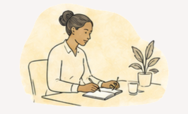 A woman sits at a desk writing in a notebook with a pen, nearby a potted plant and a coffee mug.
