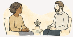 Two people having a conversation in a meeting room with a small plant on the table.