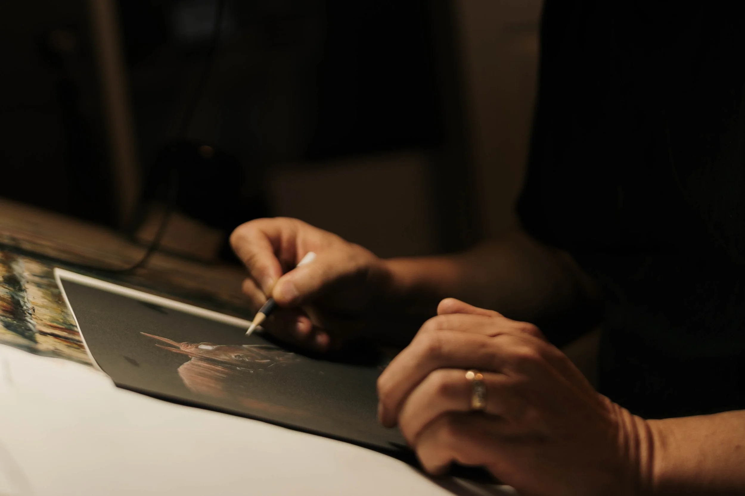 A person is signing a photograph of a horse.