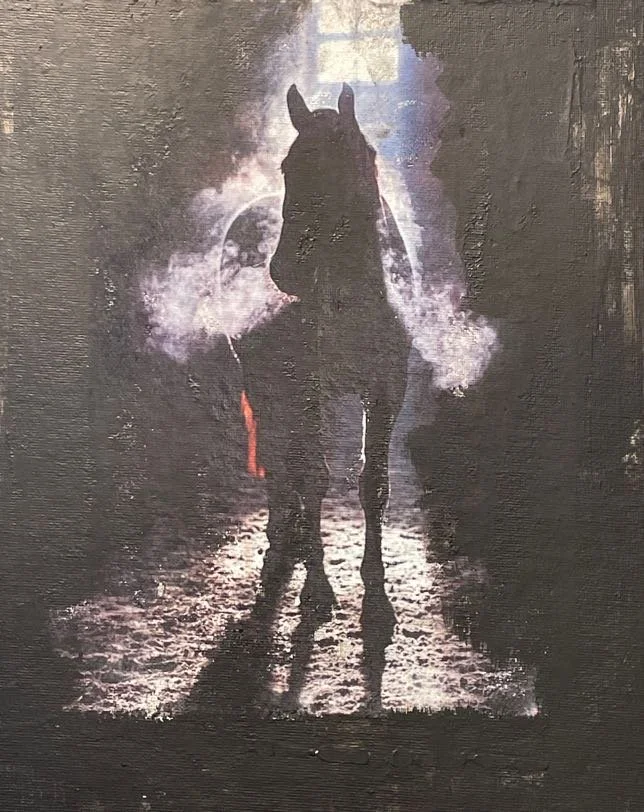Silhouette of a horse standing on a dirt path at sunset with clouds and a bright sky in the background.
