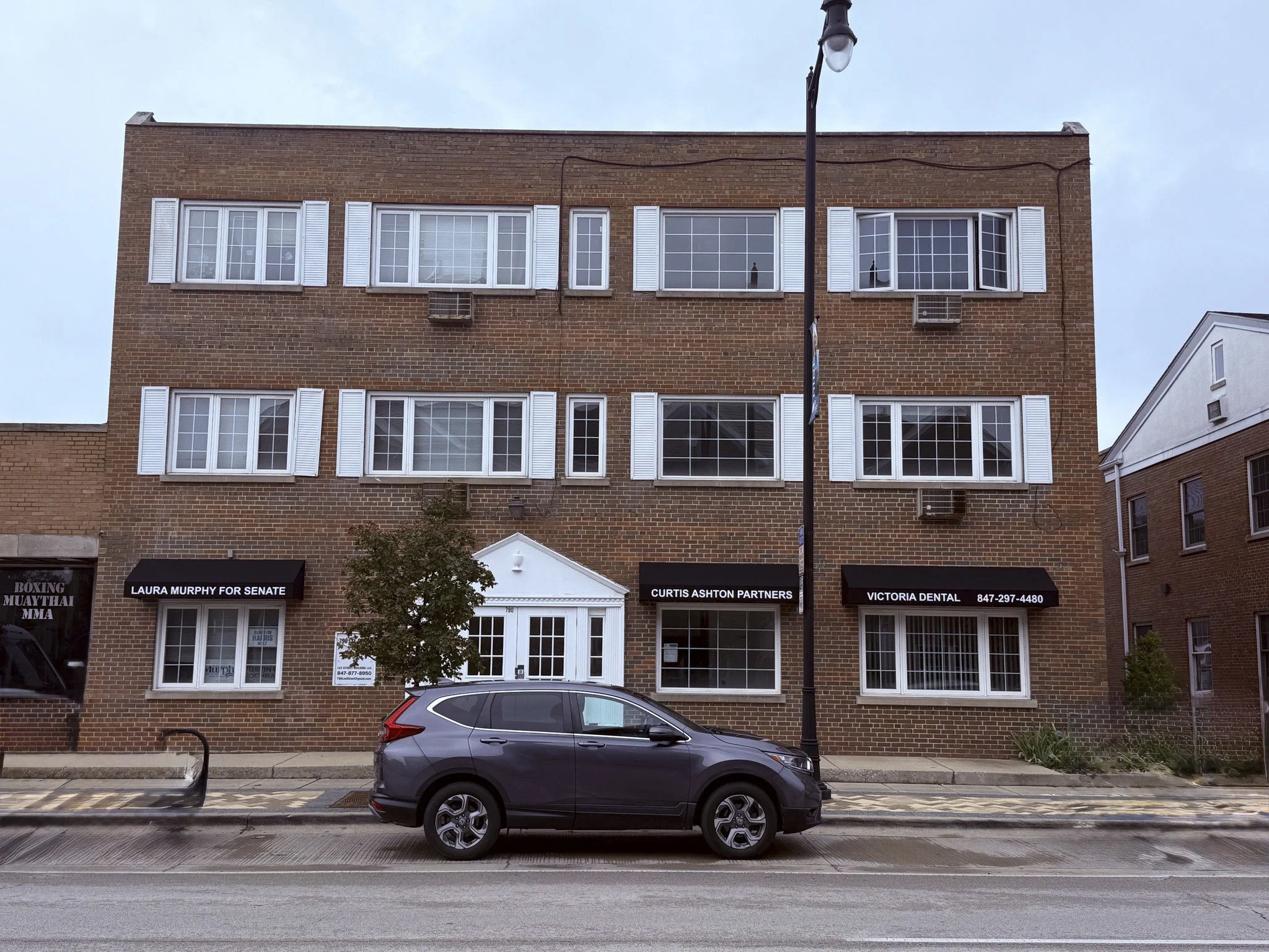 790 Lee St in Des Plaines, Illinois, a three-story mixed-use brick building with ground-floor retail and apartments above