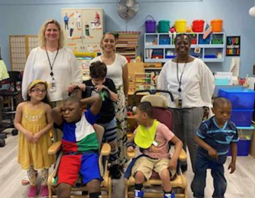 An early childhood class and their teachers pose for a class photo