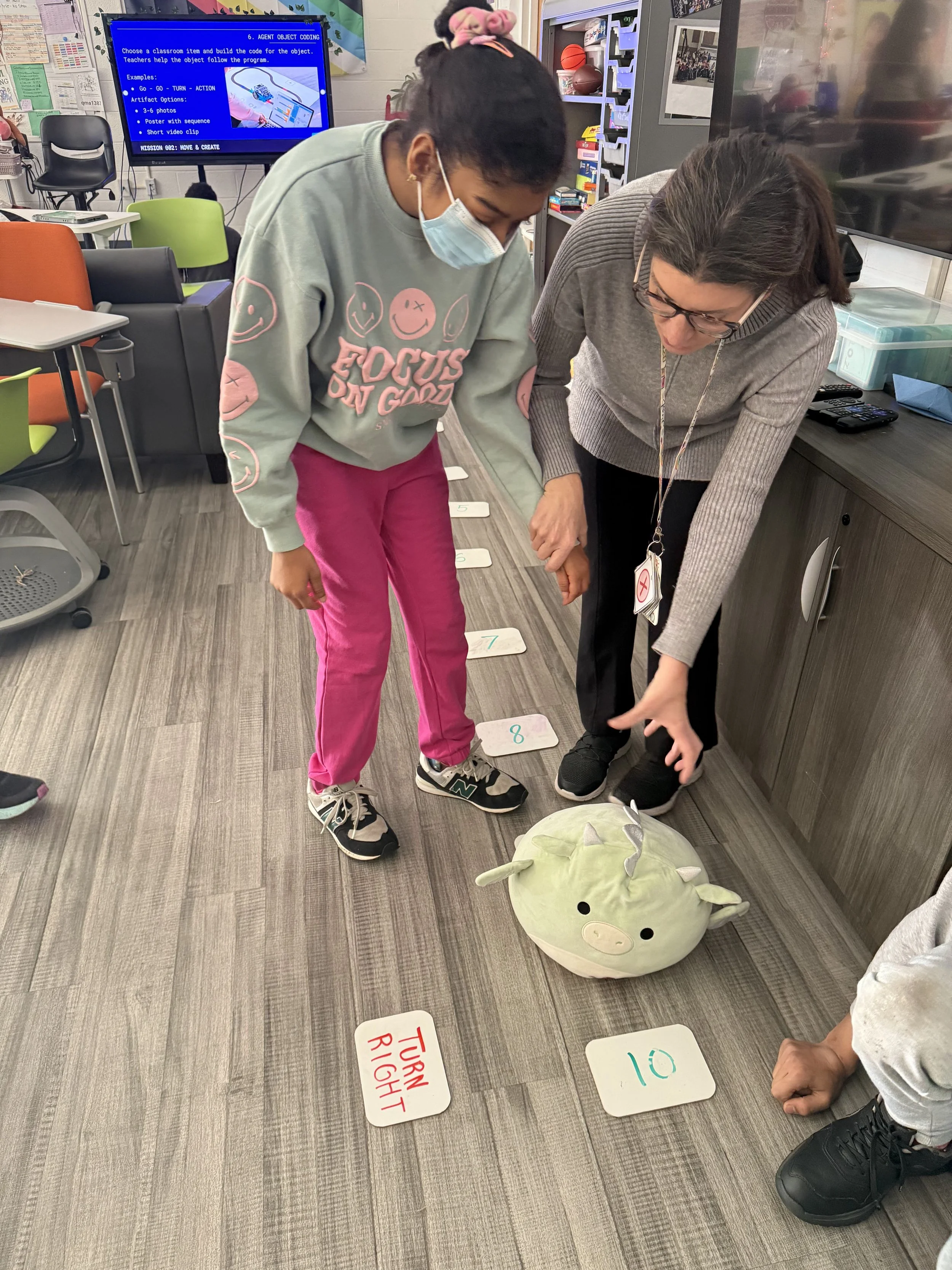 Elementary students play a matching game on the classroom floor