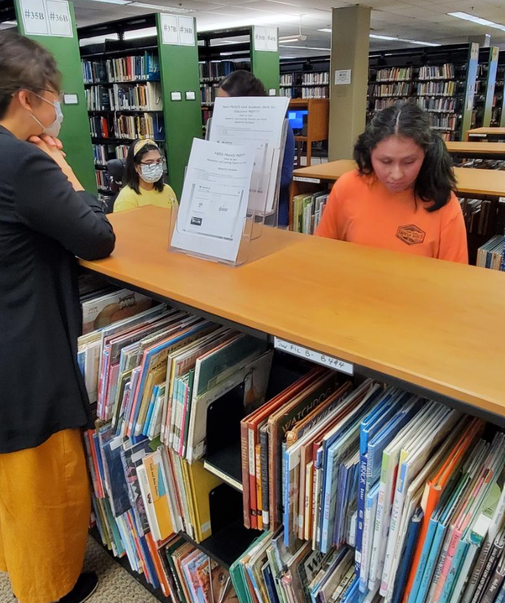 Students check out books during a visit to the public library