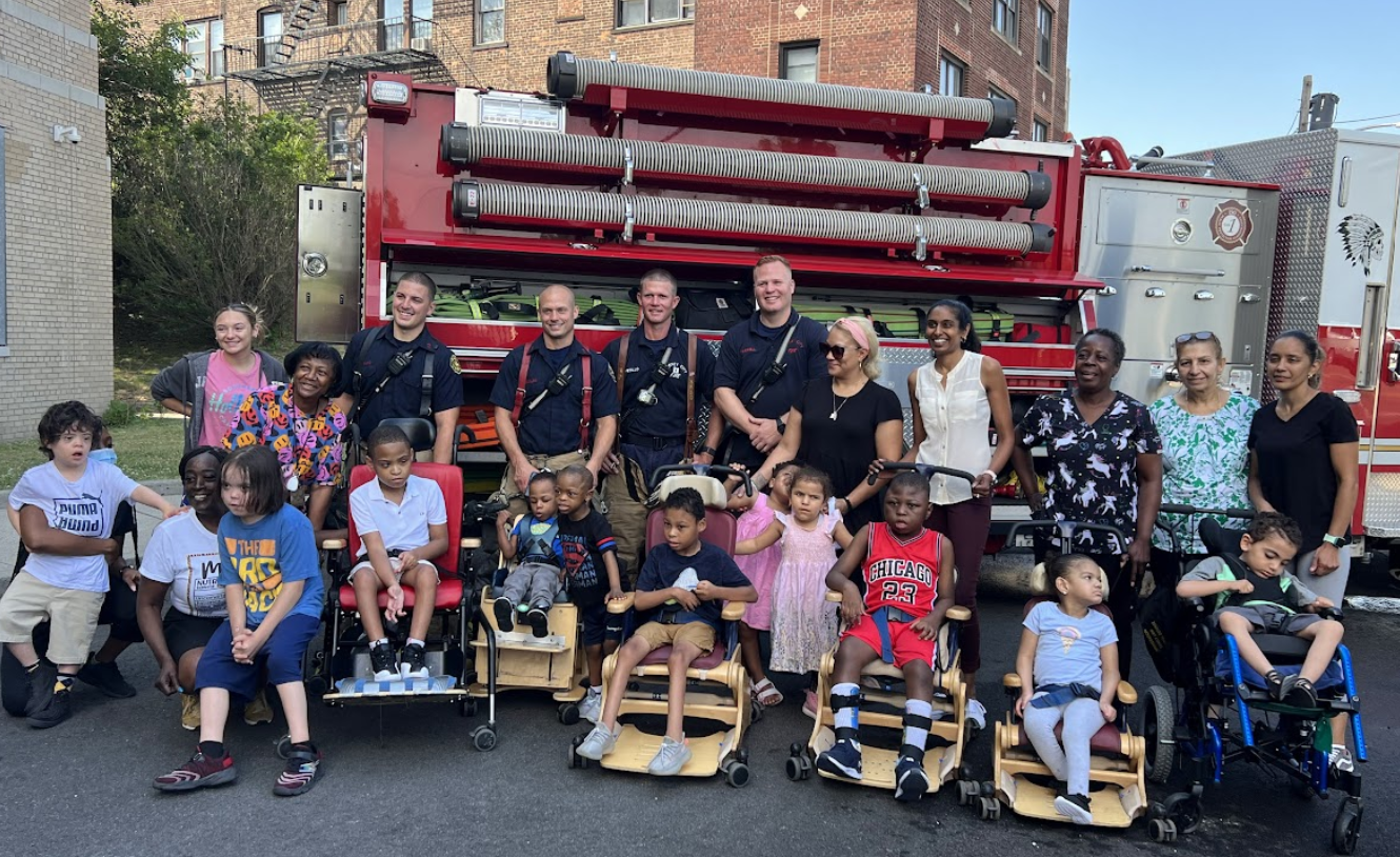 Students and staff pose with a fire truck during a visit from the fire department