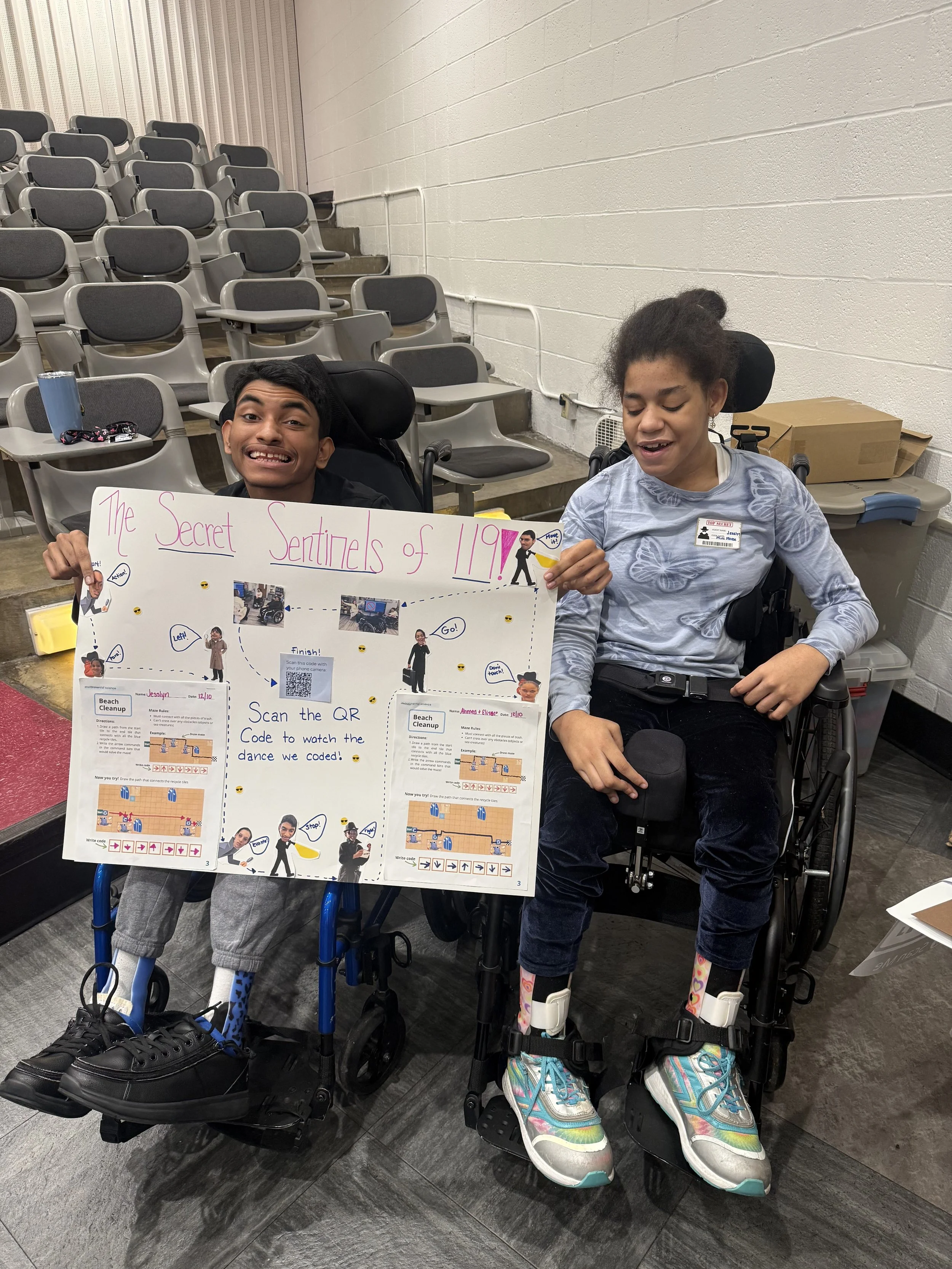 Two middle school students hold up the posters they made