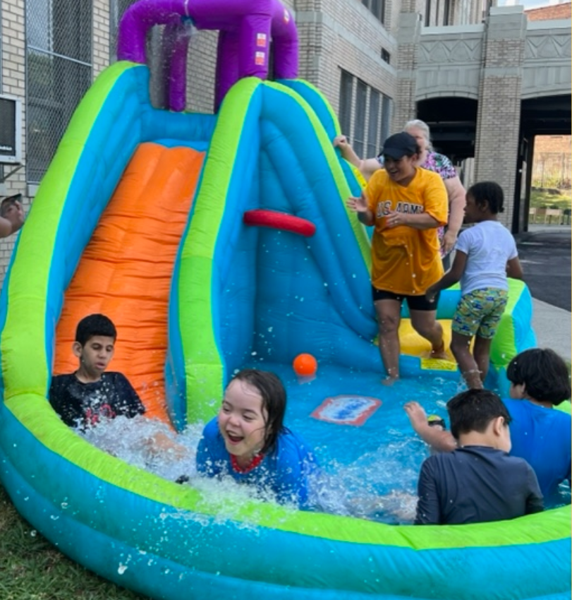 Students cool off on an inflatable water slide during Extended School Year