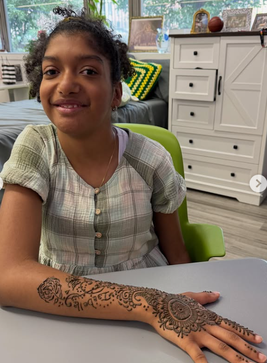 A student shows off her henna design