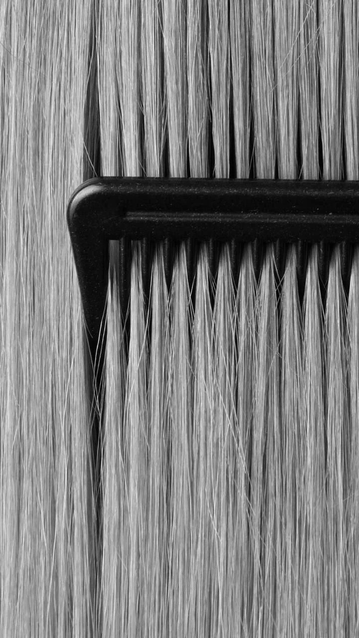 Close-up black and white photo of polypropylene hairbrush with numerous thin bristles.