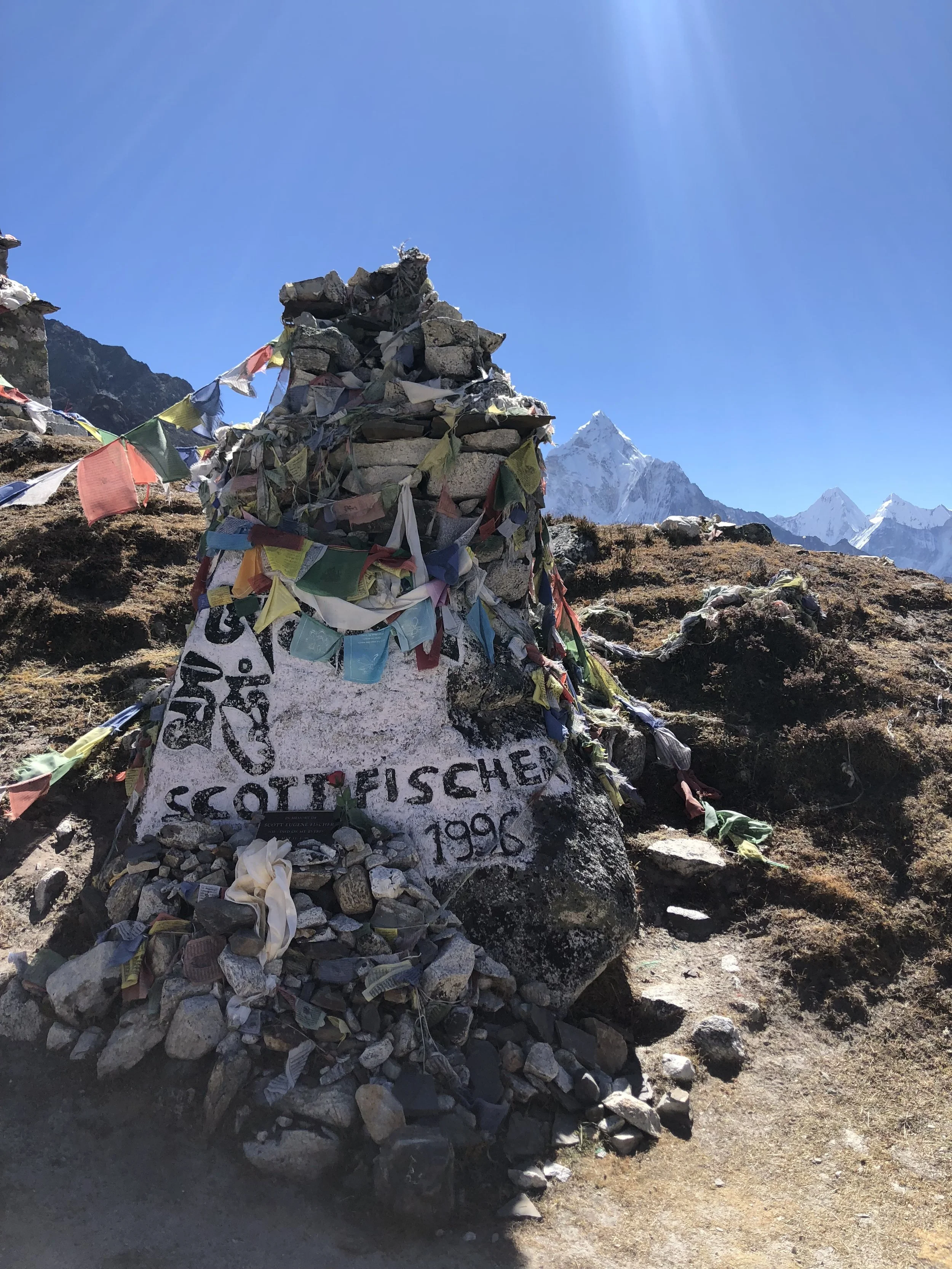 Memorial cairn for Scott Fischer at Thukla Pass in Nepal, built from stacked stones and prayer flags in remembrance of the Mountain Madness guide who died on Everest in 1996.