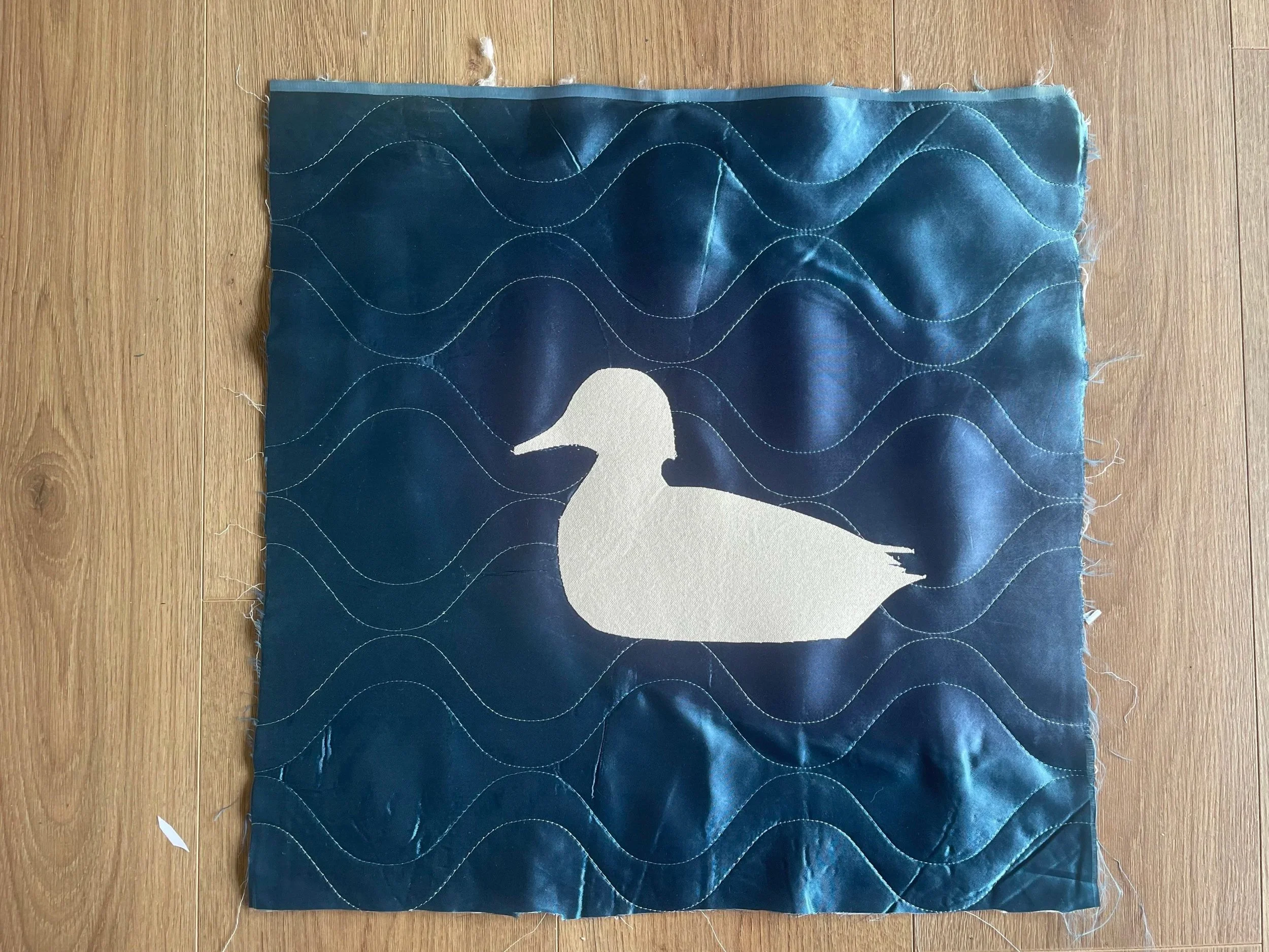  applique work in progress on upcycled satin bedspread, duck silhouette in cotton  