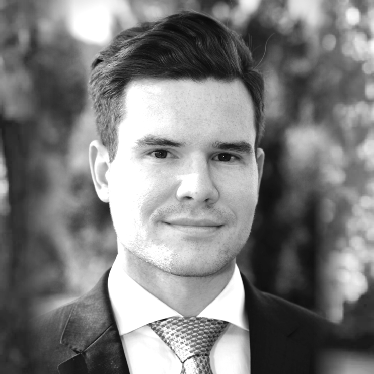 Portrait of a man in a suit with a tie, outdoors, black and white photo.