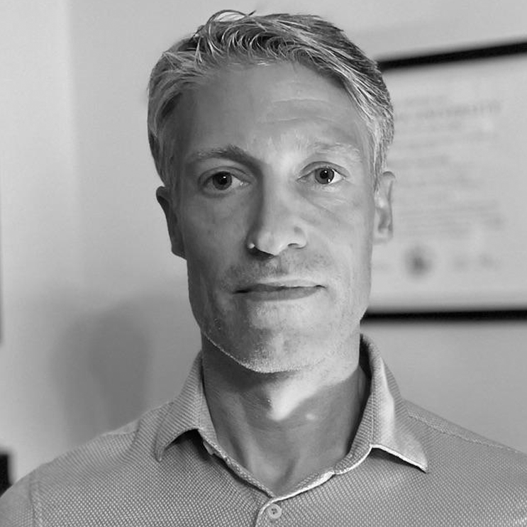 Black and white portrait of a man with short hair.