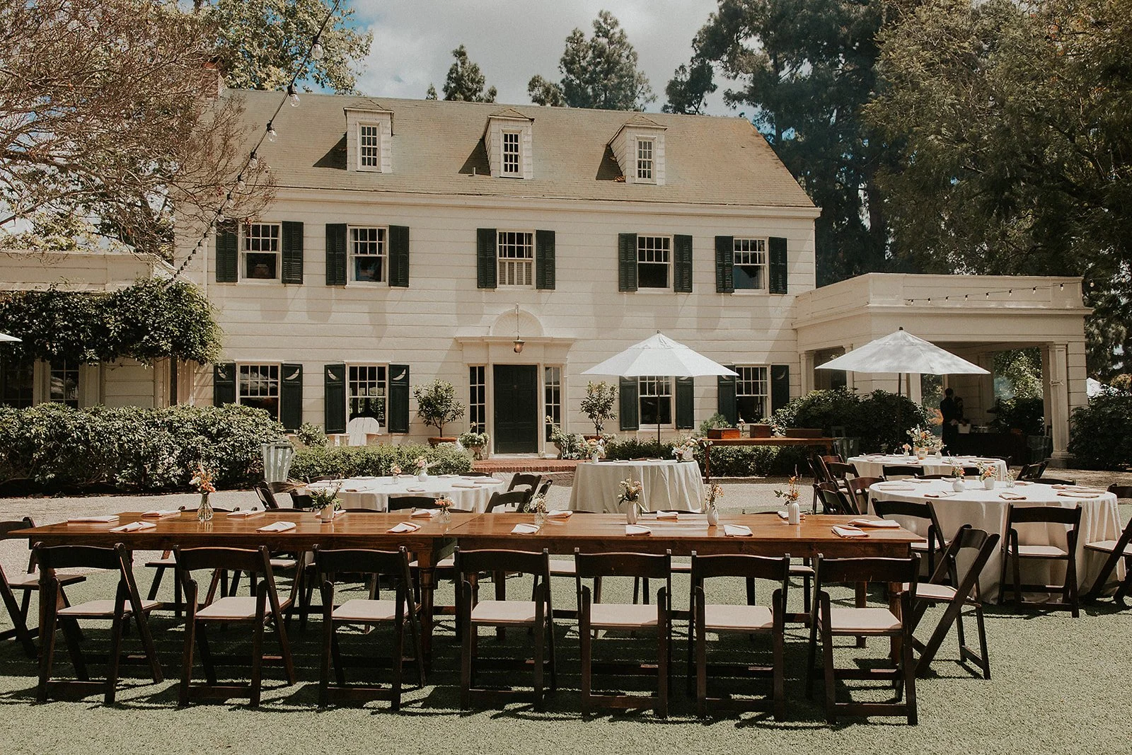 Wood tables set in the front lawn of the McCormick Home Ranch for a private fundraising event.