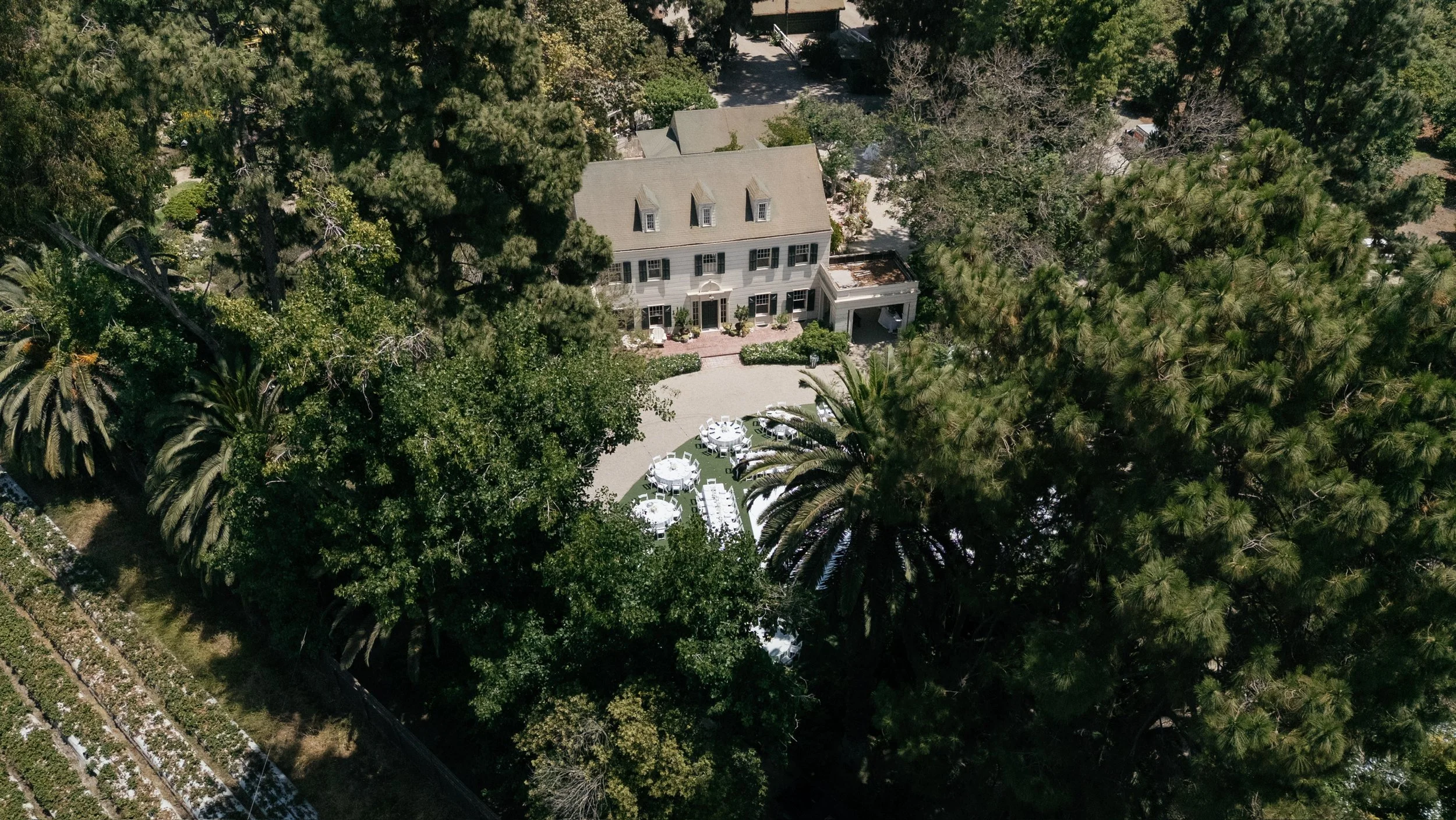 Drone aerial view of the McCormick Home Ranch all set up for a wedding event with round tables, buffet tables, white linens and elegant table settings.