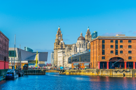 Cityscape featuring historic buildings and waterfront in Liverpool, England.