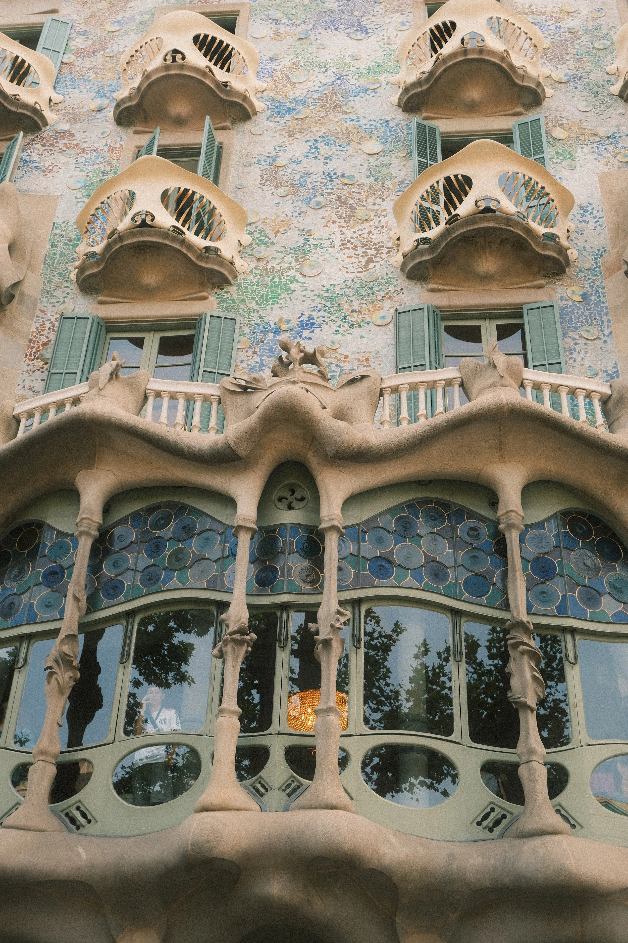 Facade of Casa Batlló, a modernist building in Barcelona designed by Antoni Gaudí, featuring colorful mosaics, organic shapes, and distinctive balconies.