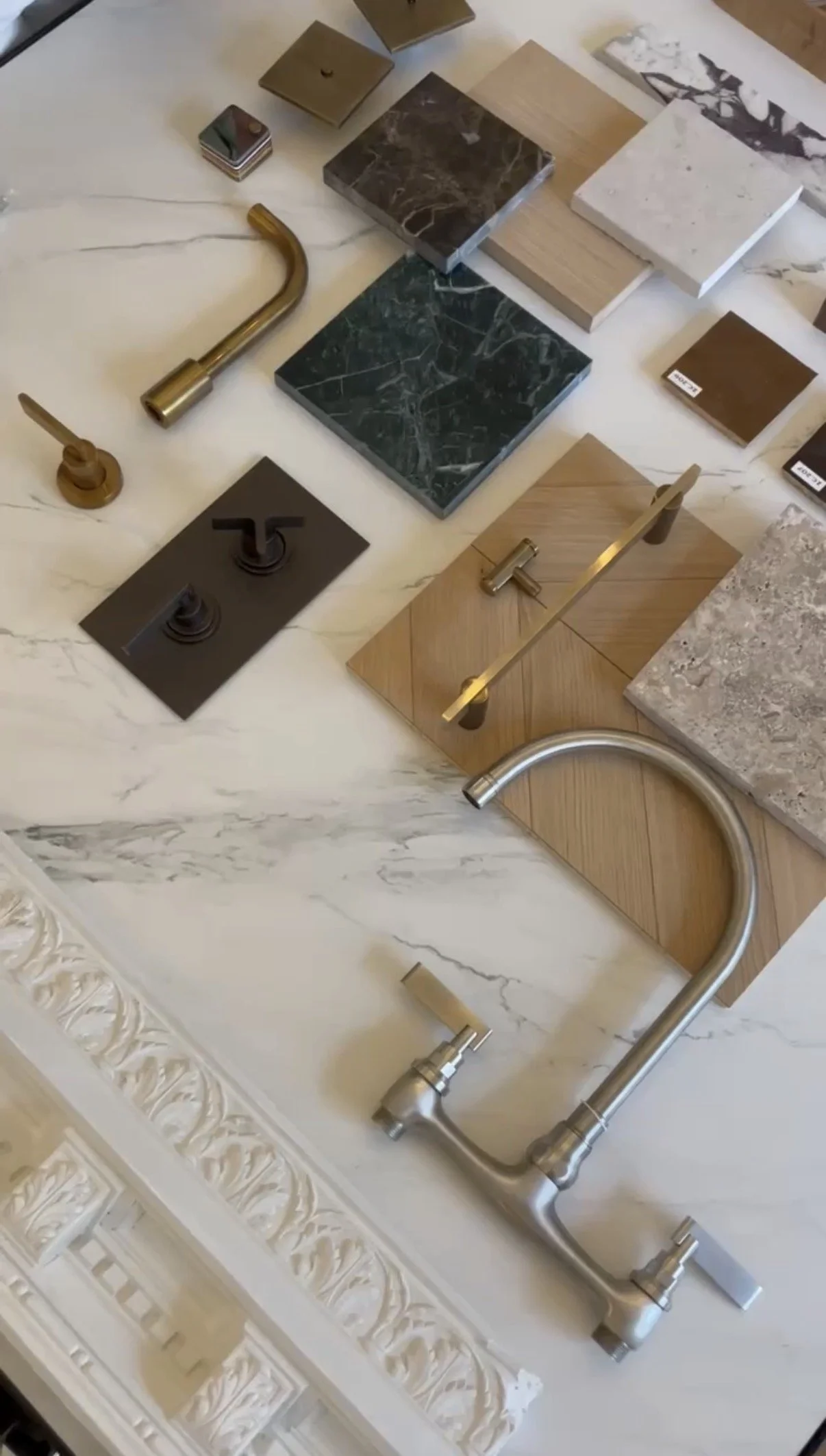 Samples of different kitchen fixtures and materials, including faucets, tiles, and countertop samples.