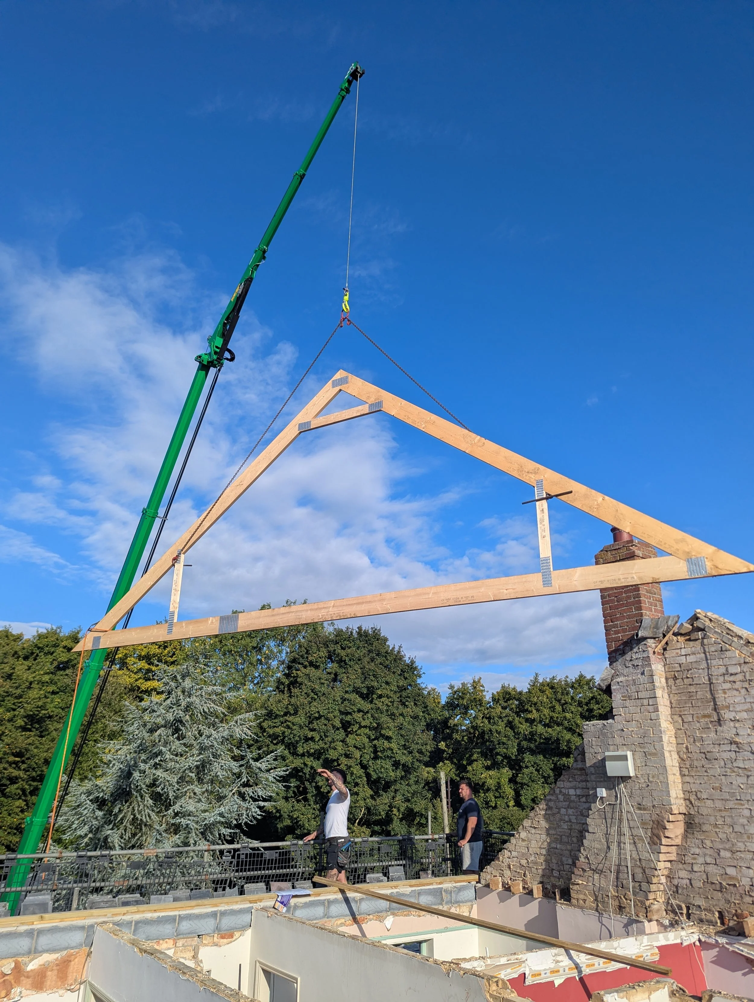 Large-scale roof truss installation using a crane for a new build project in North Norfolk.