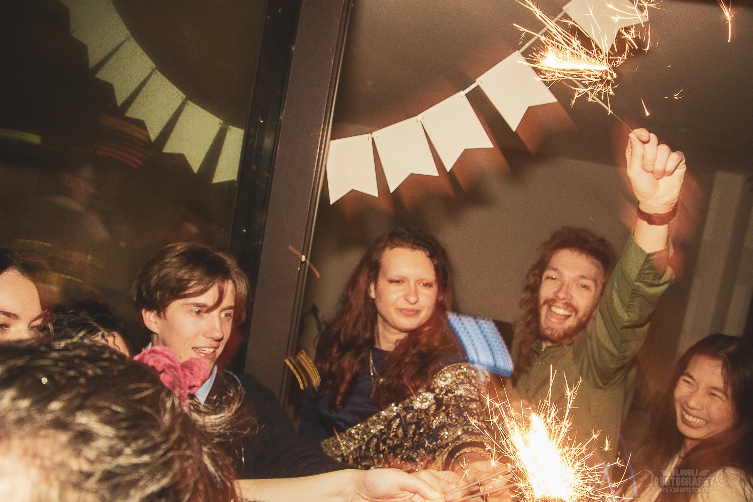 Group of friends celebrating with sparklers and party decorations