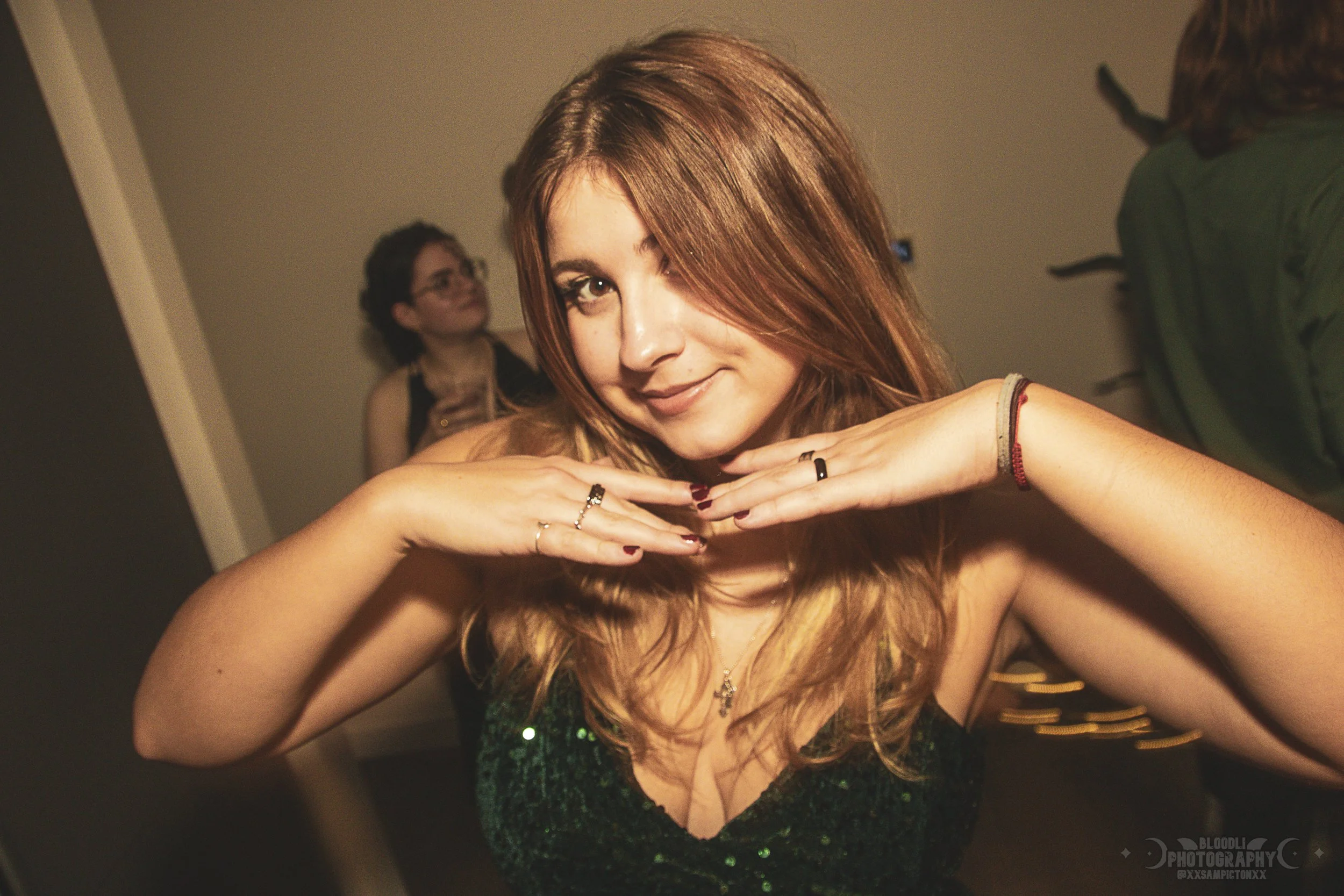 Young woman with red hair making a playful pose at a party.