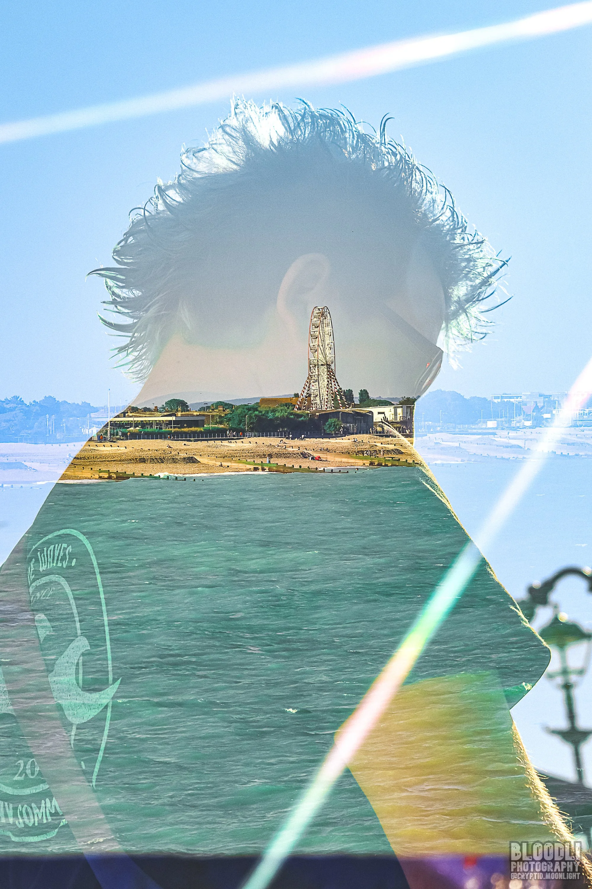 Double exposure photo of a person with spiky hair wearing sunglasses, superimposed with an amusement park scene featuring a tall Ferris wheel and waterfront.
