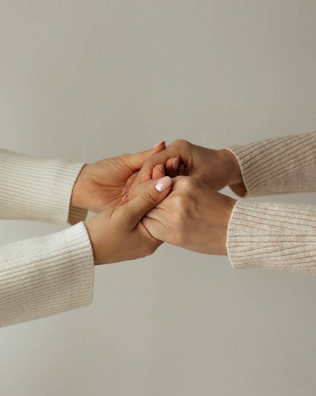 Two people holding hands for support