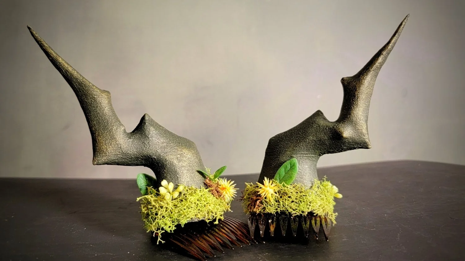 small, clip-in, dragon-style, jagged greenish-brown horns with bright greenish-yellow moss around the base, and tiny flowers and leaves appearing to grow from the moss