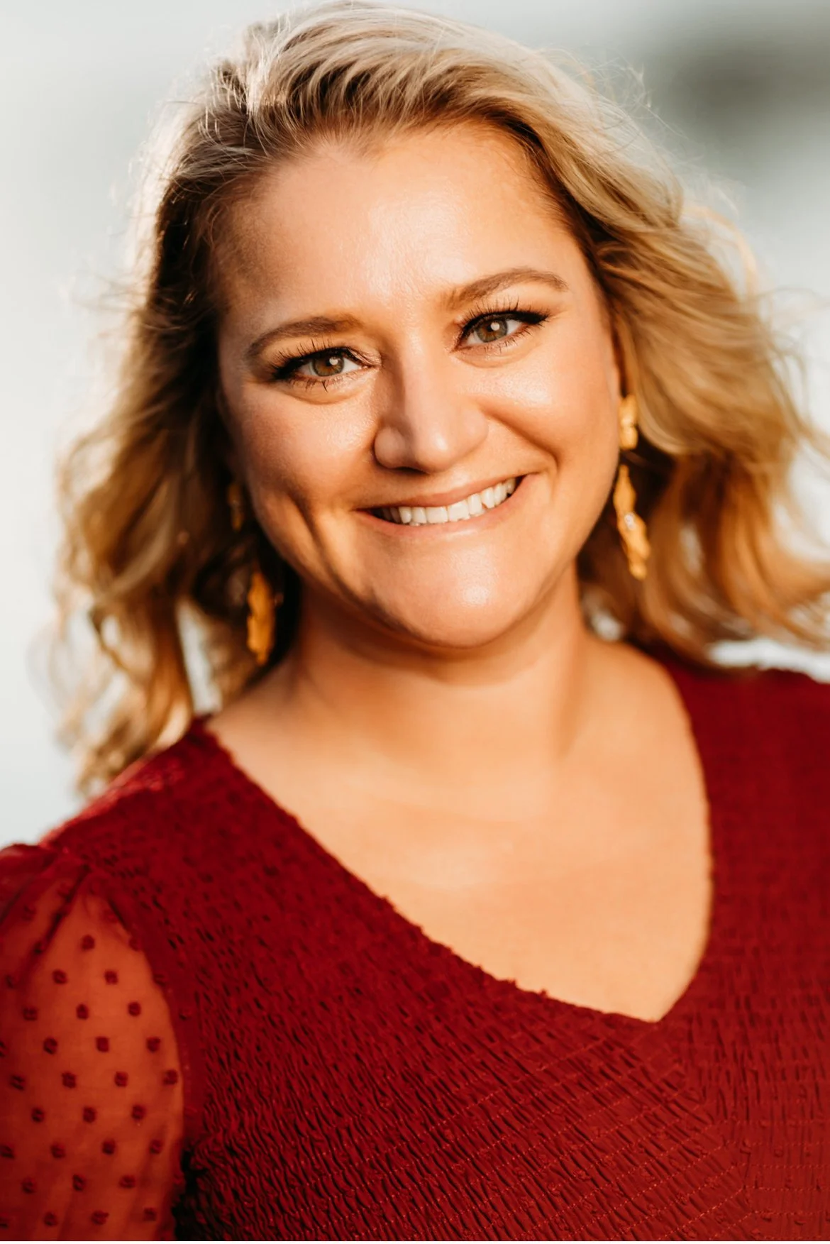 Portrait of a woman in a red shirt against a blurred background