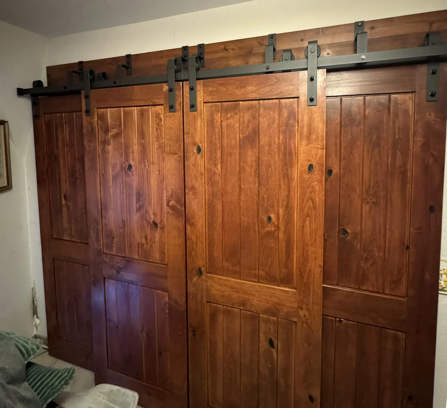 wooden barn doors on closet with wrought iron hardware