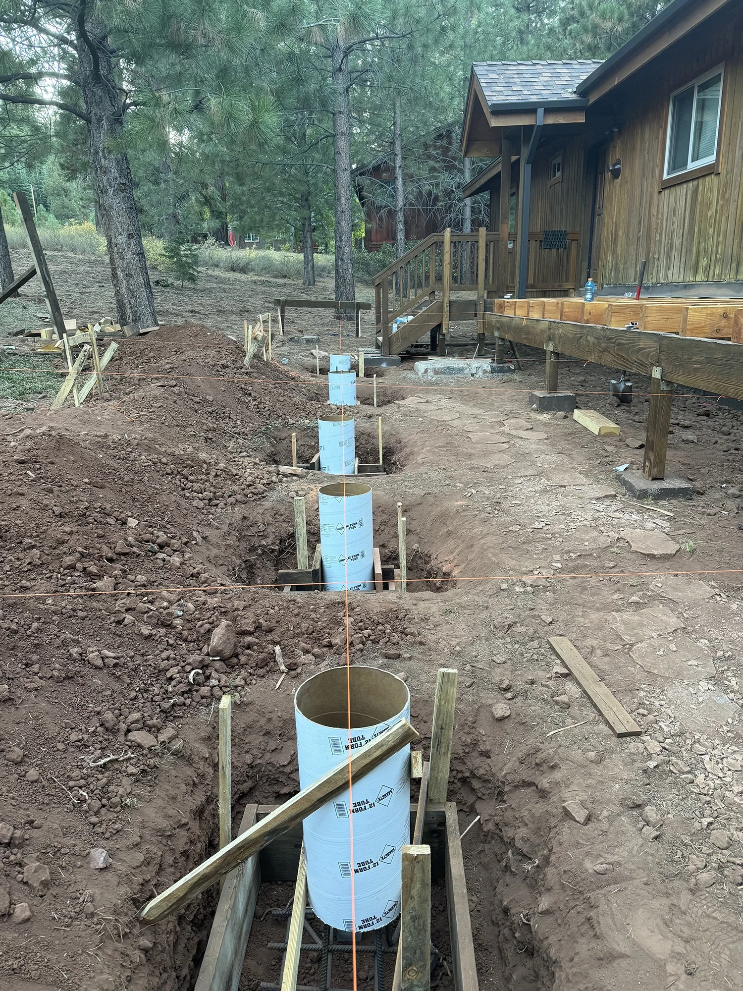 excavated ground prepared with framing to pour deck footings on single level house