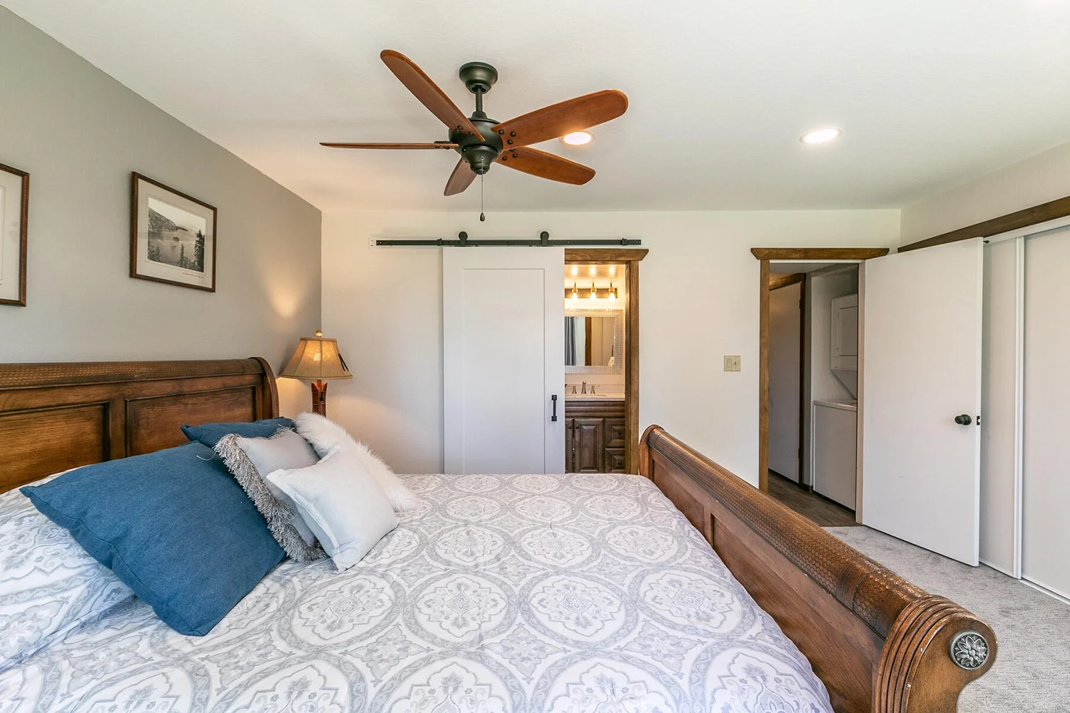master bedroom with fan and barn door entrance to bathroom