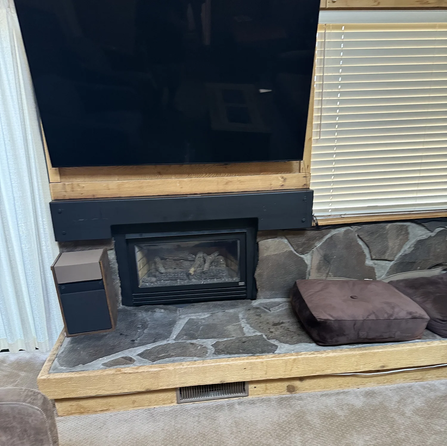 gas fireplace insert with rock and carpet in living room