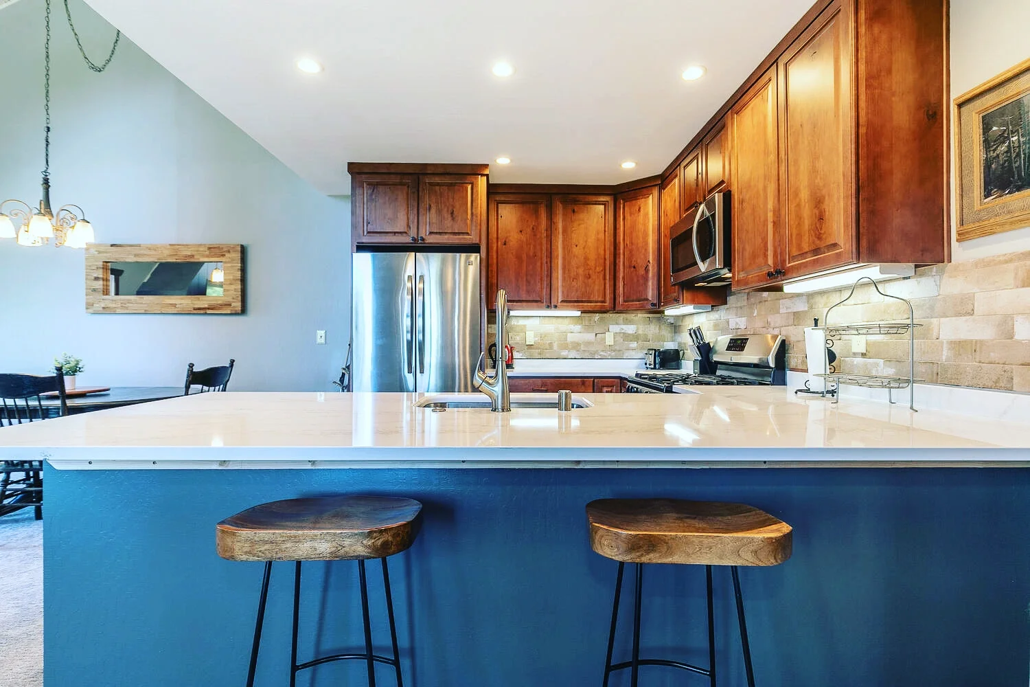 kitchen with wood cabinets marble countertops and rustic barstools