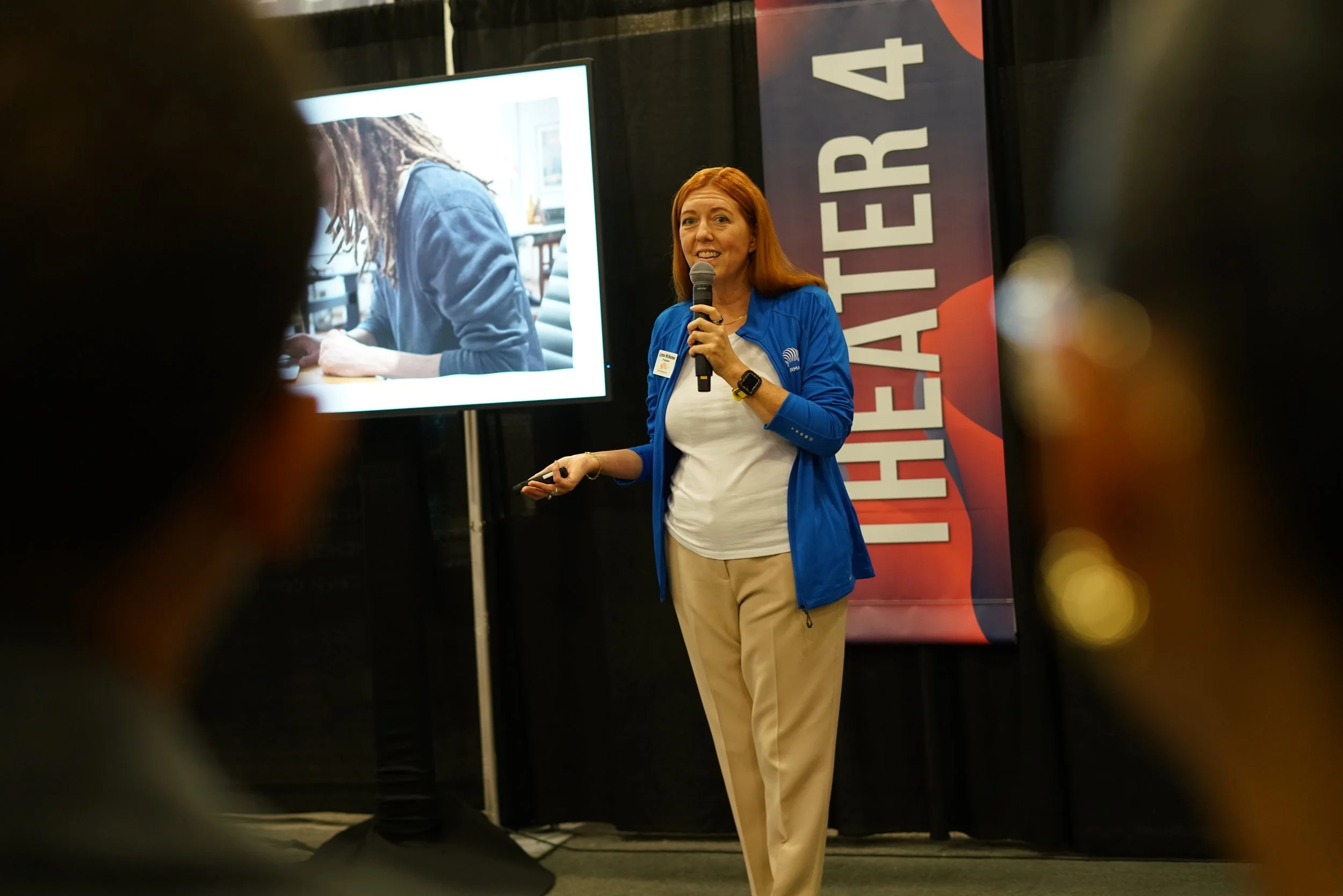 Lynne McNamee speaking to a business audience at a conference.