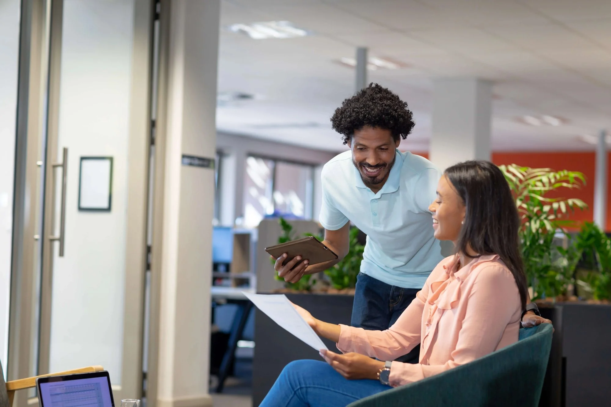 Two colleagues collaborating on a document in a modern workplace.