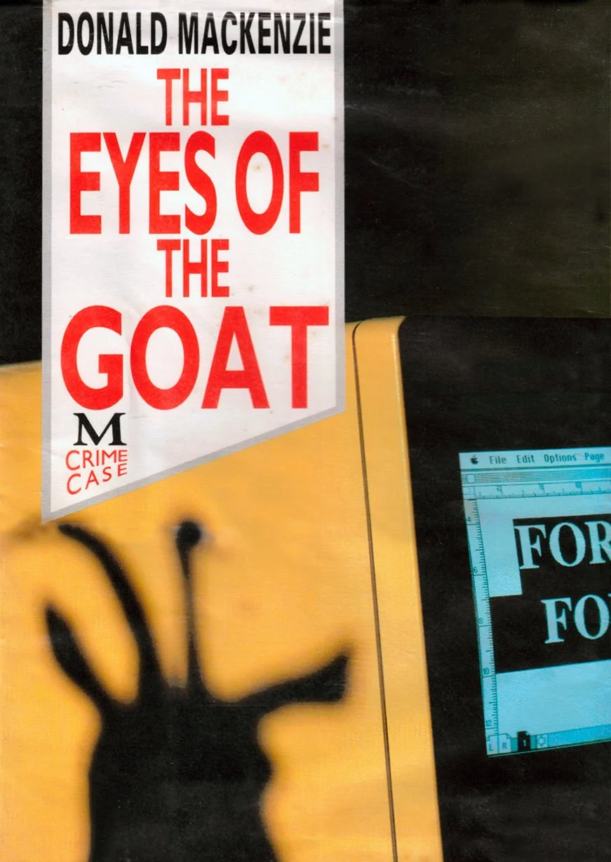 A book cover titled 'The Eyes of the Goat' by Donald Mackenzie with subtitle 'Crime Case,' and part of a desk with a yellow folder and a computer screen displaying a document.